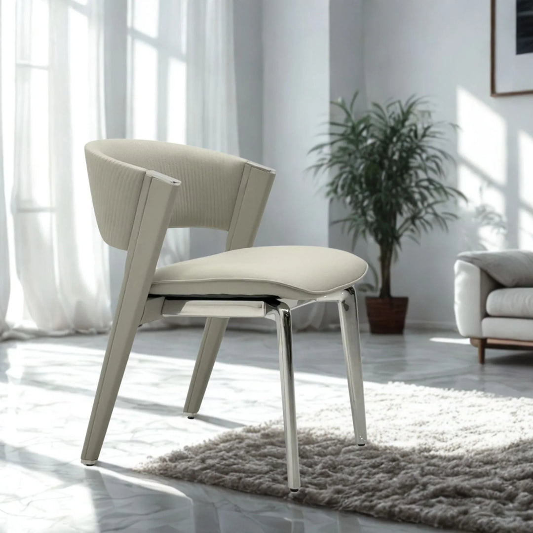 Modern cream upholstered dining chair with chrome metal legs in a bright living room.